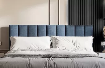 A serene bedroom featuring a blue headboard, white bed, and a striking black accent wall for a modern touch.