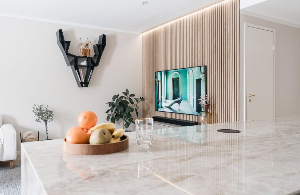 Sleek white kitchen with wooden slat wall panels