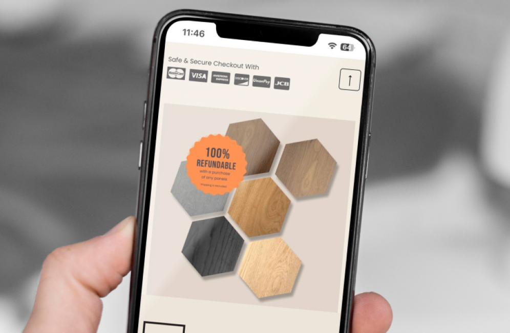 A person using a smartphone to explore a wood flooring app, featuring premium hexagon acoustic panel options.