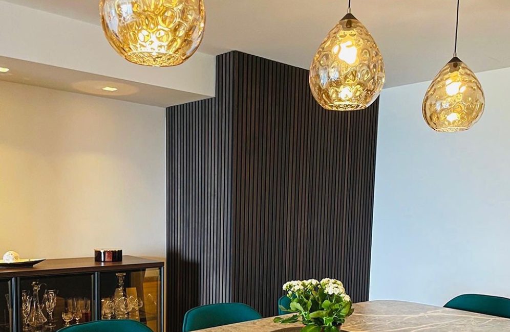 A stylish kitchen and wooden paneling, featuring slat wall panels in the kitchen area