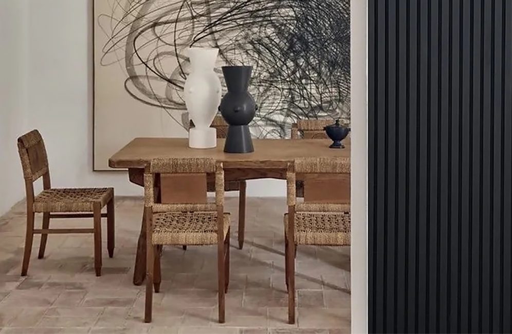 A dining room featuring a black accent wall, a black radiator, and an elegant painting enhancing the space's ambiance.