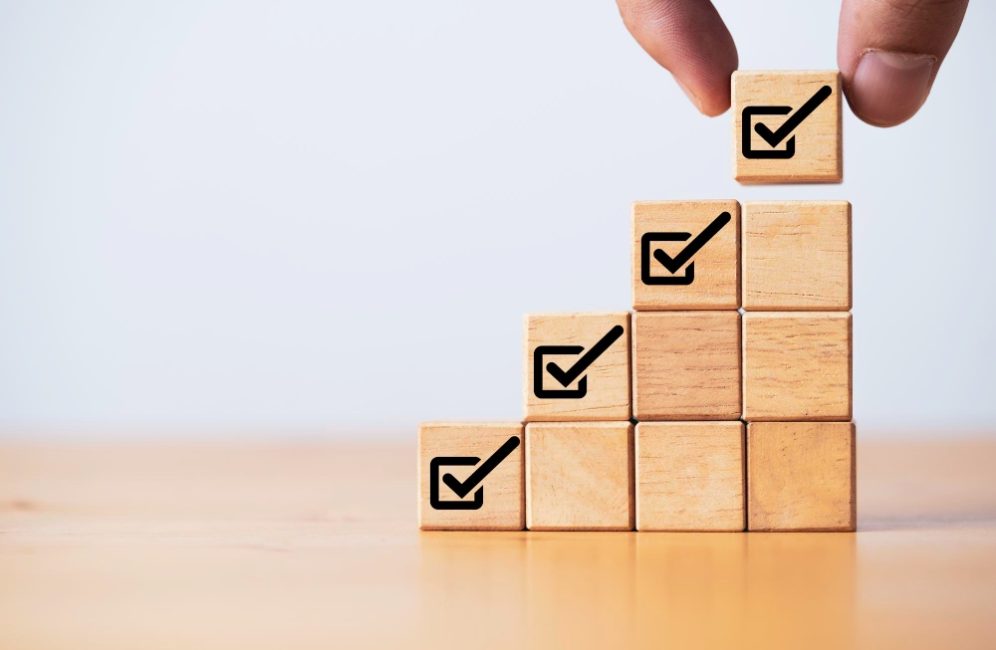 A person arranging wooden blocks marked with check marks, illustrating the advantages of using wooden wall paneling.